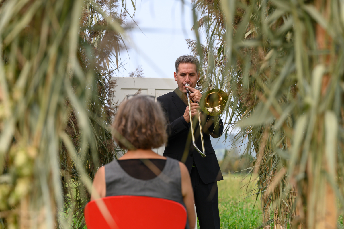 Diego Sanz López (Posaune) in der Schilf-Installation im „Junkeracker“.